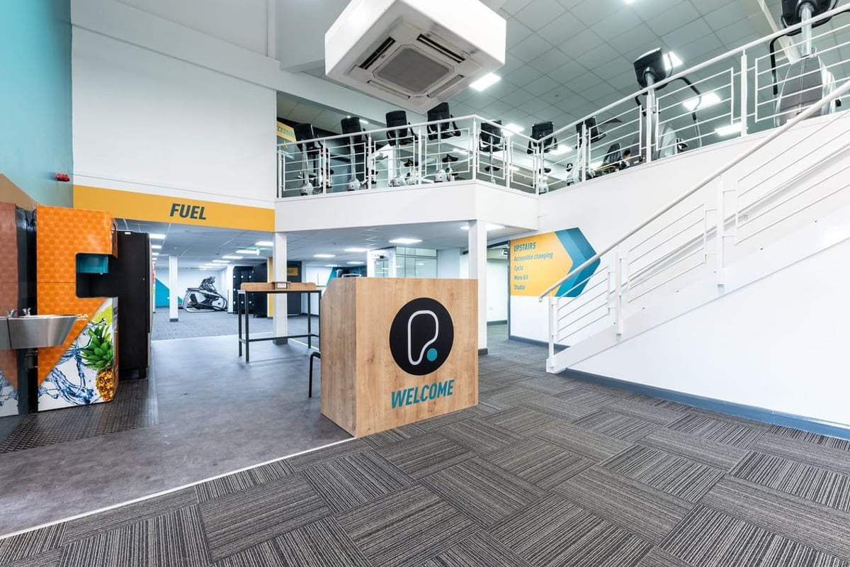 PureGym Bangor Northern Ireland: Reception area with welcome desk, brand signage, and modern industrial design aesthetic.