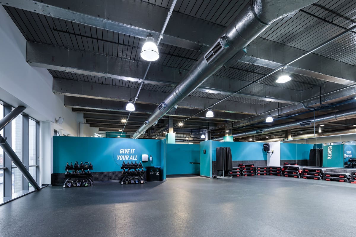PureGym Cardiff Central: Rows of exercise bikes, resistance machines, and mirrored walls in a gym studio.