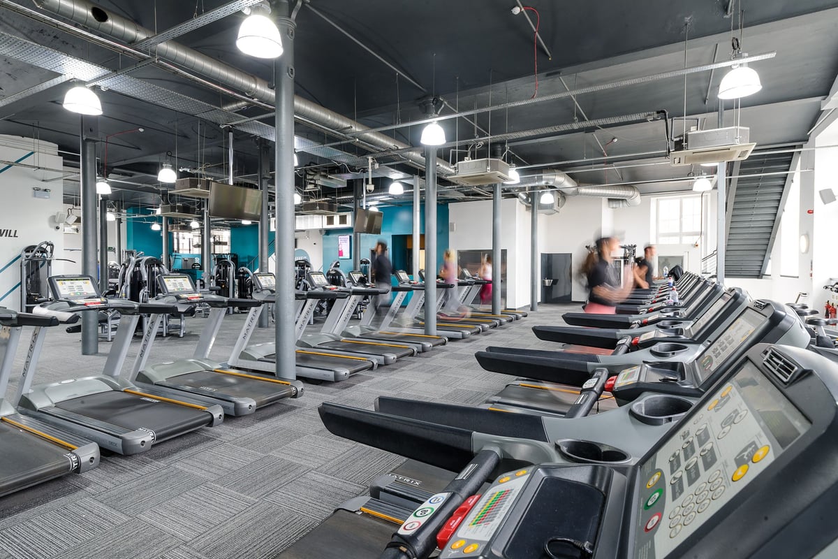 PureGym Dundee: Rows of treadmills, ellipticals, and other cardio machines in a modern gym setting.