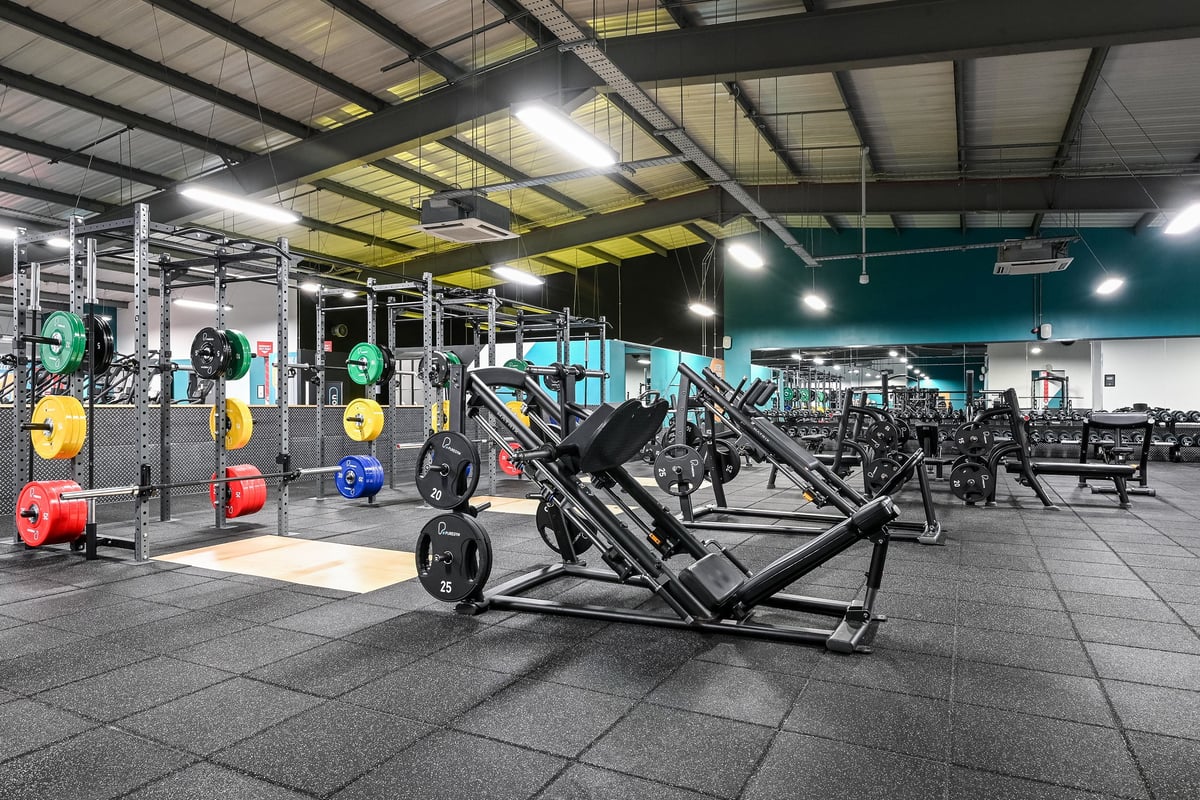 PureGym Canterbury Sturry Road: Weights racks, barbells, benches and rubberized flooring in a brightly-lit workout facility.