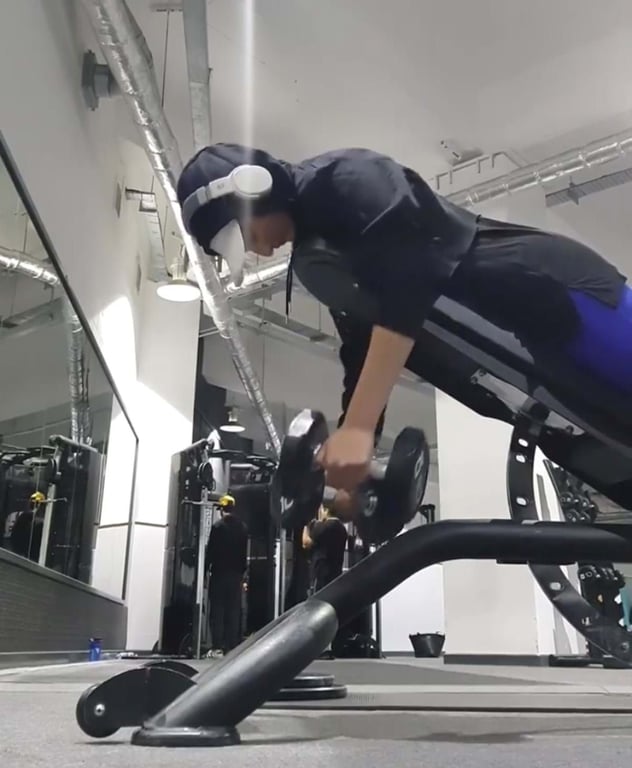 Person wearing headphones and a mask lifting dumbbells on an incline bench in gym