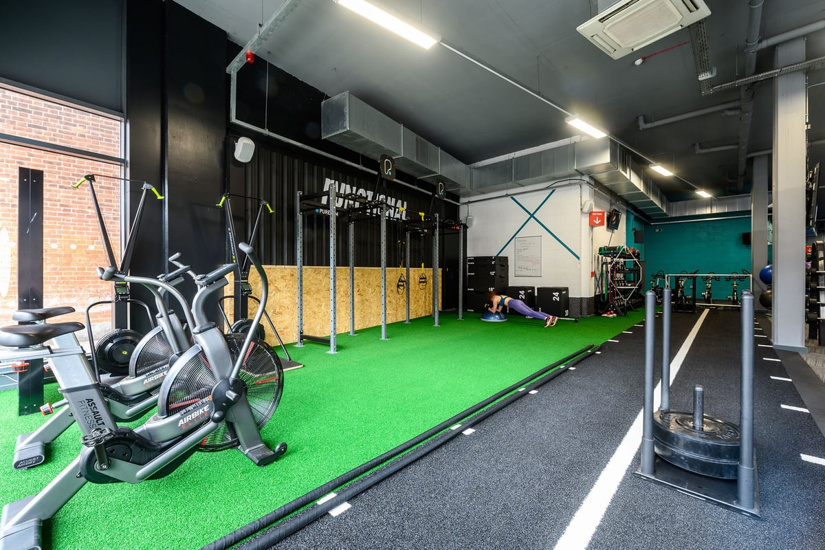 PureGym London Acton: Turf area, spinning bikes, plate-loaded machines, lockers, rubberized floor.