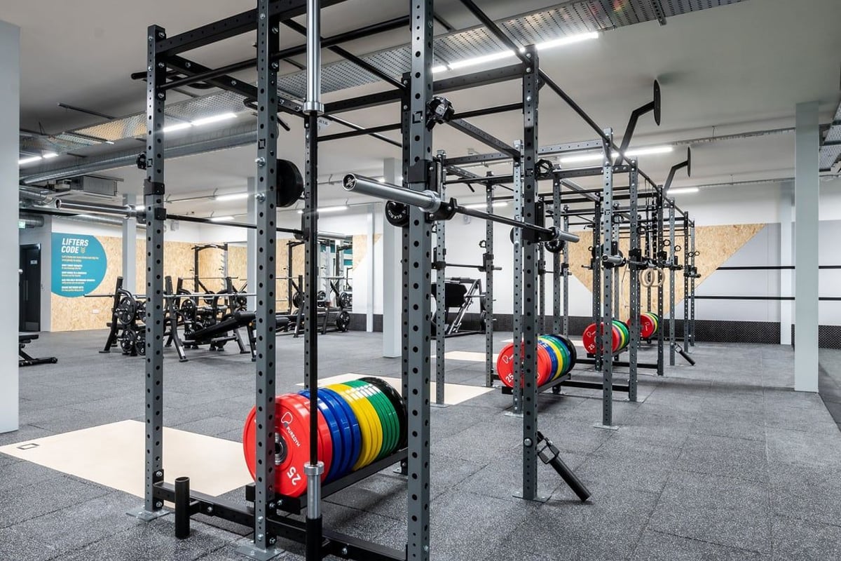 PureGym Durham Arnison: Squat racks, weight plates in various colours, barbells, and rubberized flooring in a gym setup.