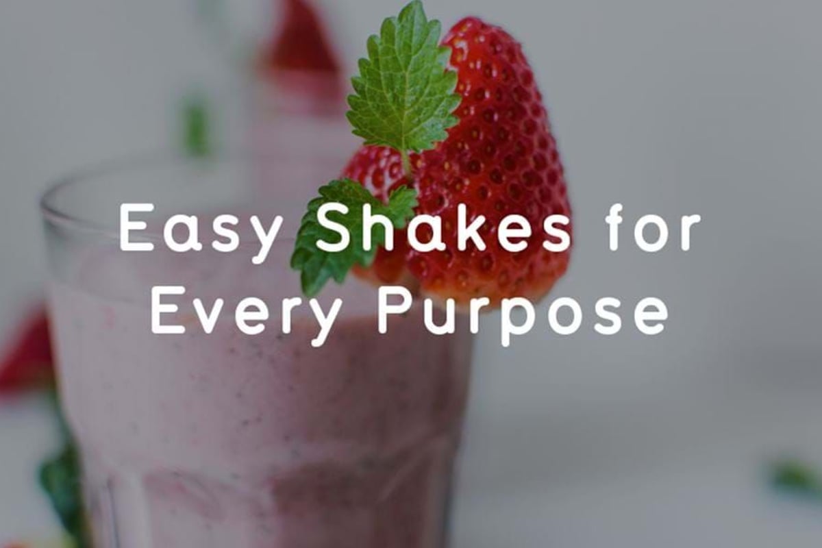 Strawberry milkshake in a glass garnished with a strawberry and a mint leaf