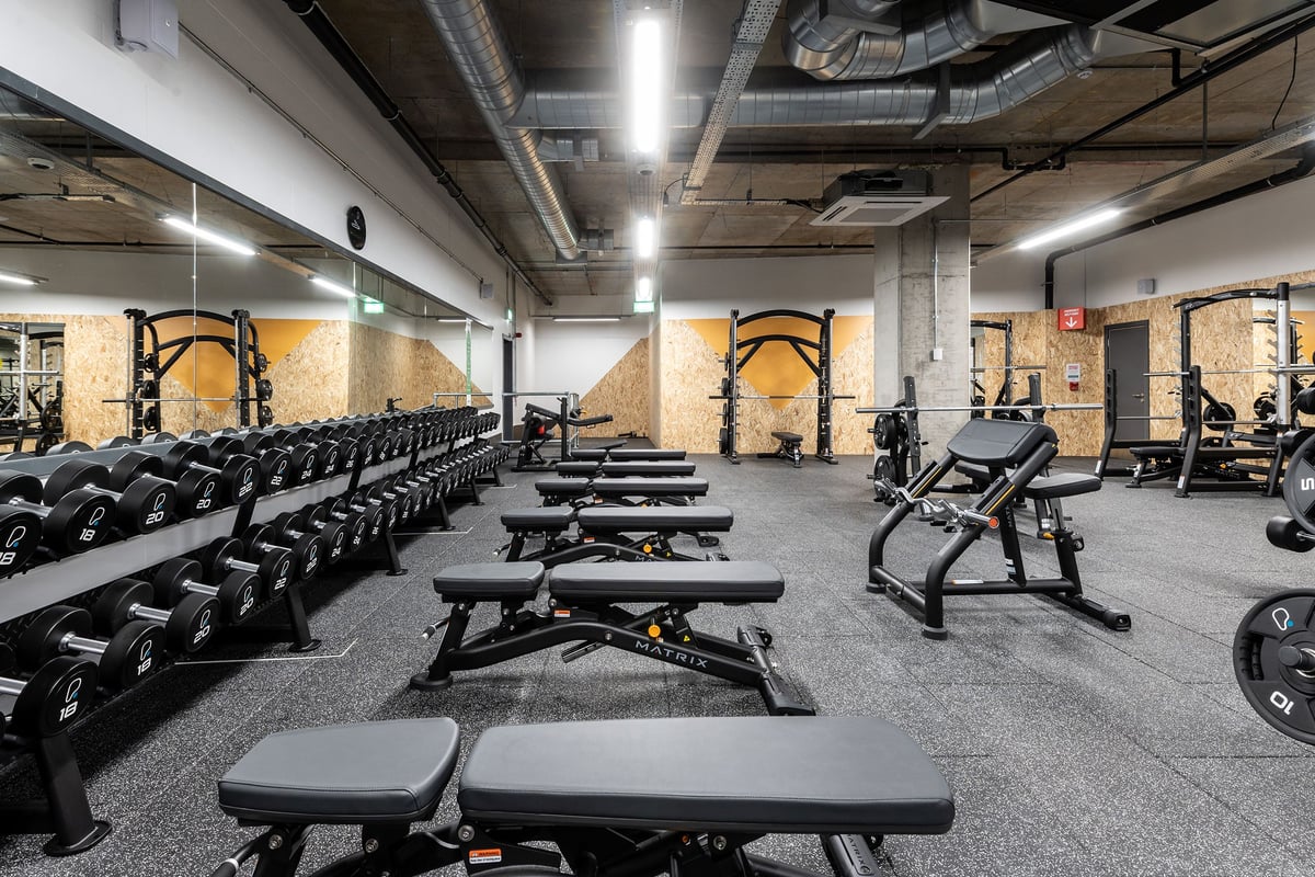 PureGym London Hoxton: Rows of weight benches, dumbbells, weight racks, and resistance machines on rubberized flooring.