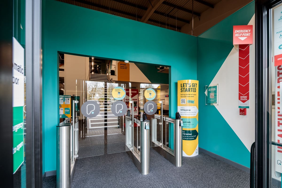 PureGym Frome: Turnstiles, self-service kiosks, and a changing room entrance area.