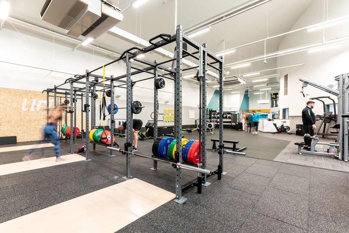 PureGym Bangor Northern Ireland: Rig for functional training, weight plates, squat racks, and rubberized flooring.