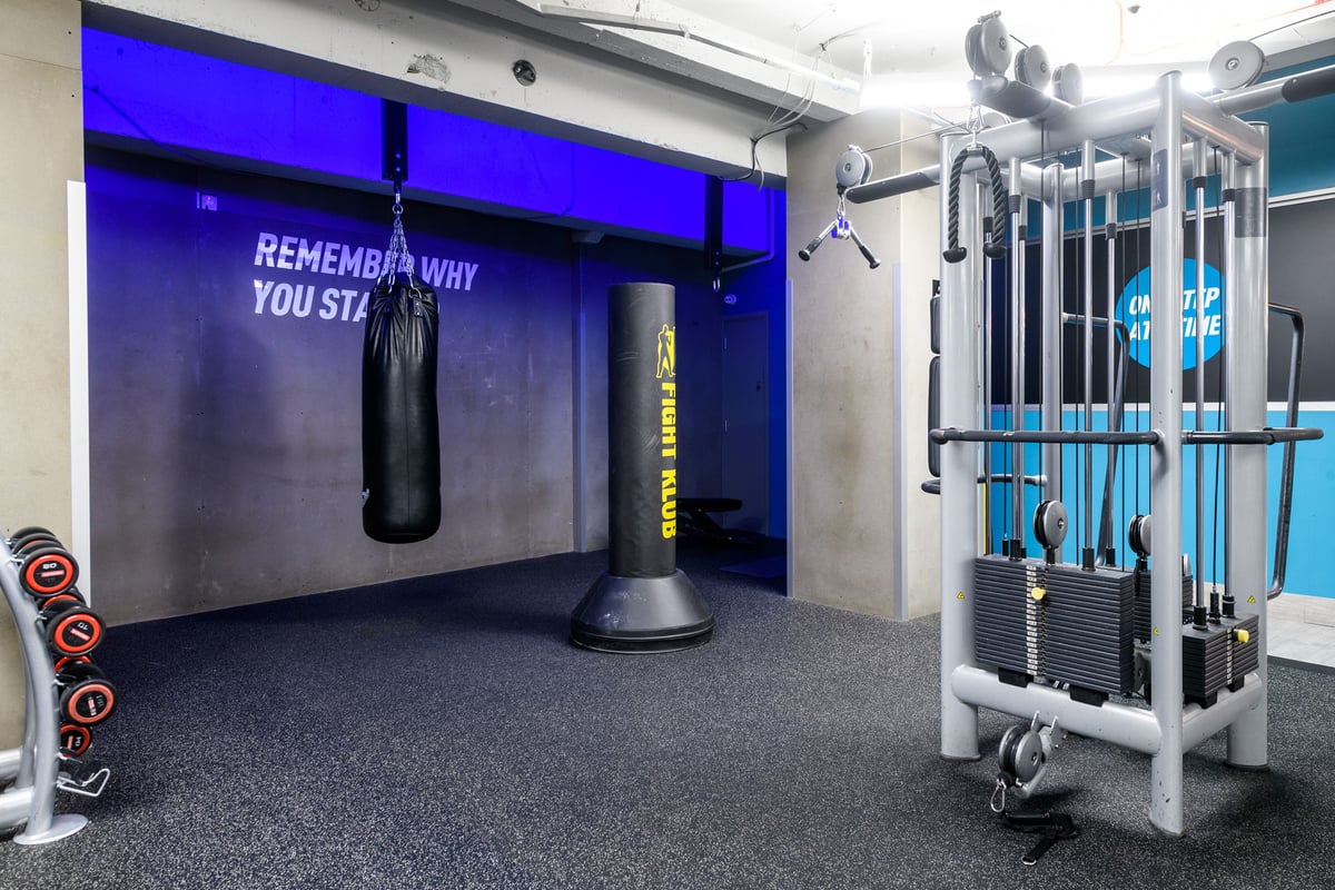 PureGym London Lewisham: Punchbag, weight racks, resistance bands, and motivational wall text.
