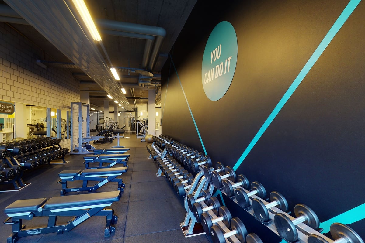 PureGym Chur: Reihen von Hantelbänken, Hanteln, Langhanteln und gummiertem Bodenbelag.
