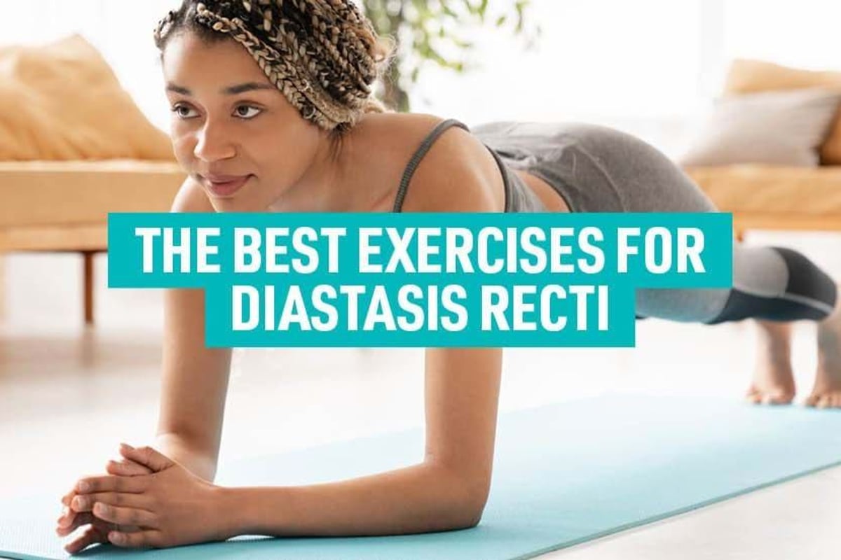 Woman in sportswear doing plank exercise on a blue mat in a living room