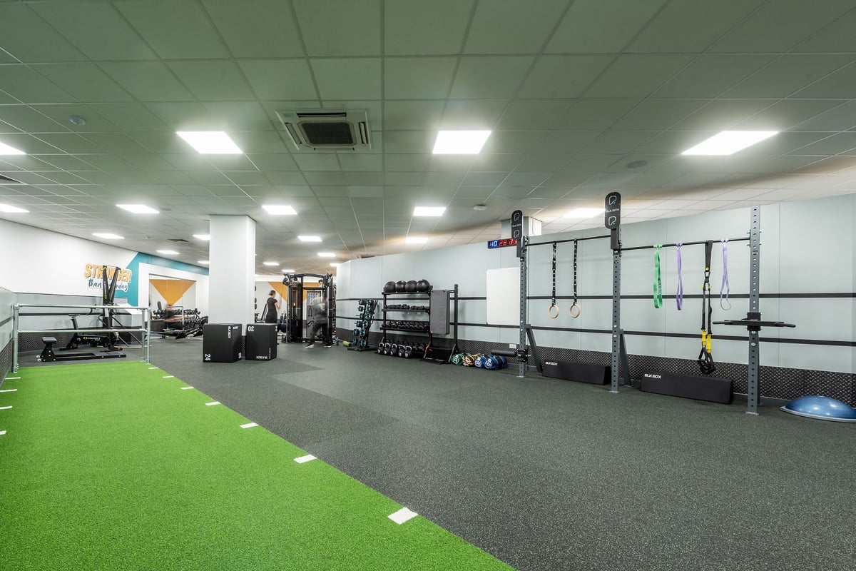 PureGym Birmingham Beaufort Park: Rig frames, lifting platforms, rubberised floors, green turf area, free weights.