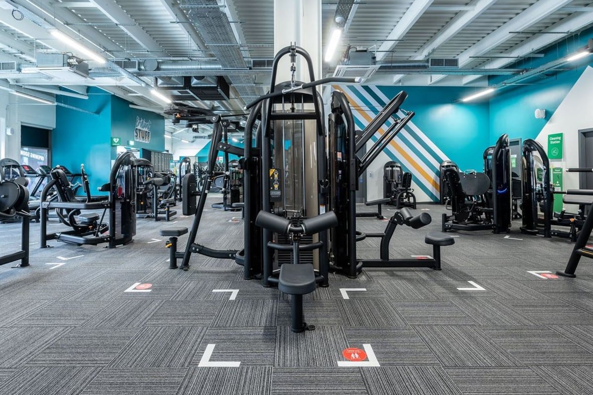 PureGym Aldershot Westgate Retail Park: Weight machines, resistance equipment, and teal accent walls in a gym studio.