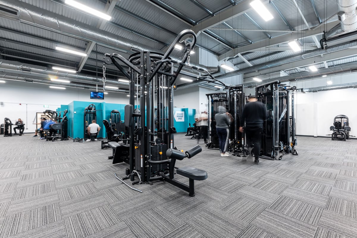 PureGym Birmingham West: Weight machines, cable stations, benches, rubberized flooring in a spacious gym interior.