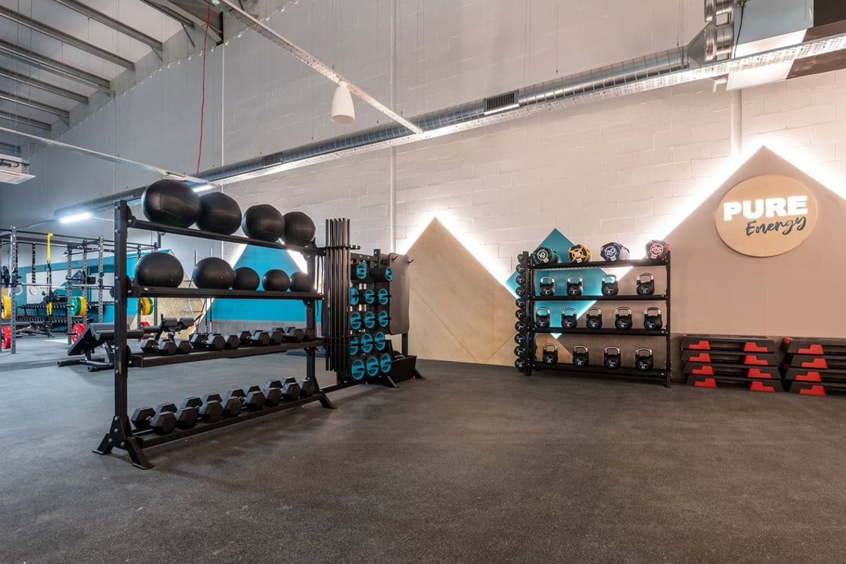 PureGym Lanark: Racks with weights, medicine balls, storage crates, and branded Pure Gym branding.