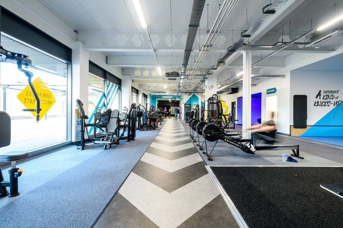 PureGym Telford: Gym studio with weight machines, free weights, mirrors, chevron floor pattern.