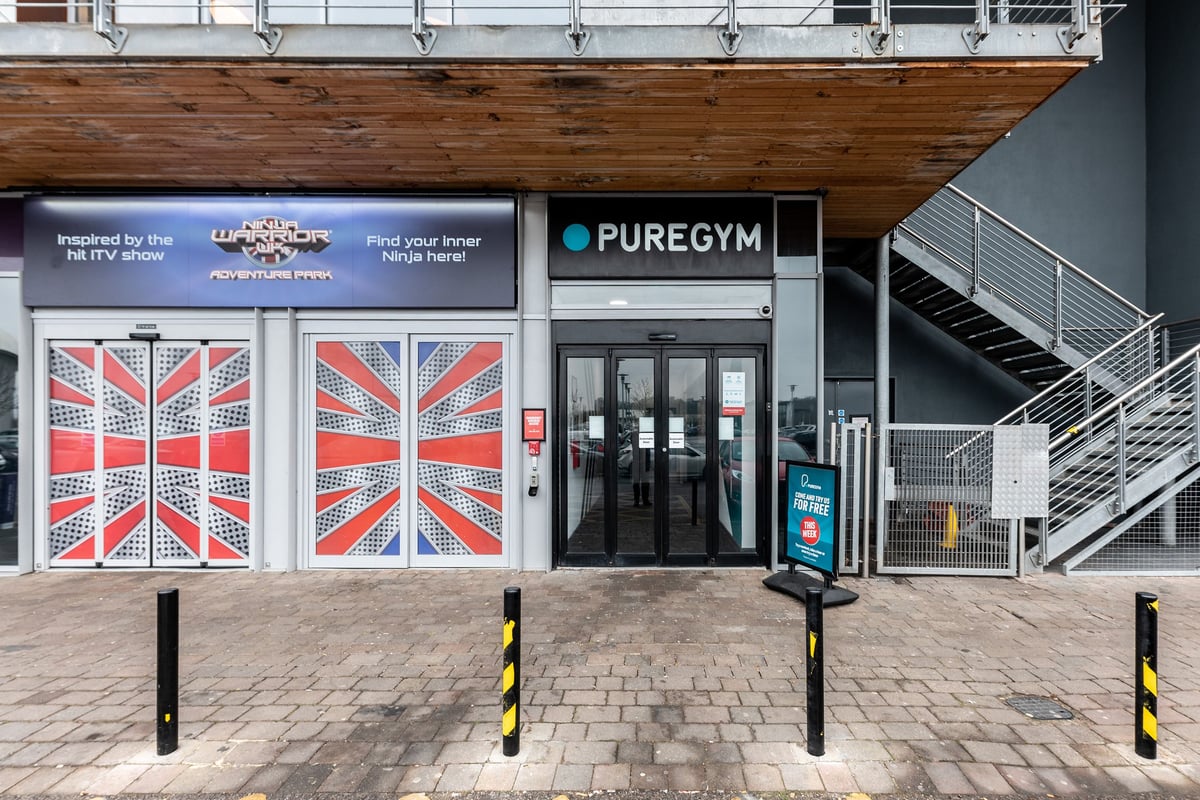 PureGym Chatham: PureGym entrance with Union Jack motif doors, outdoor signage and bike racks.