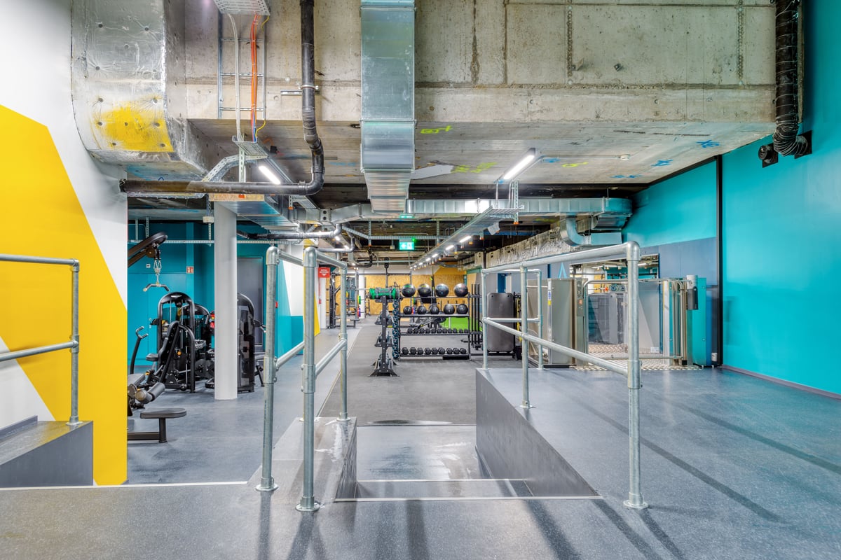 La zone d’entrée du gym à Schaffhouse avec une rampe industrielle en acier et une main courante