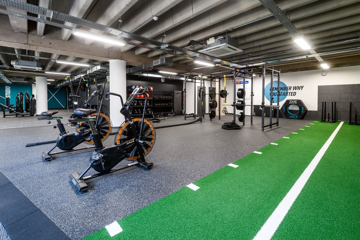 PureGym Birmingham Arcadian Centre: Gym studio with exercise bikes, resistance machines, turf area, and rubberized flooring.