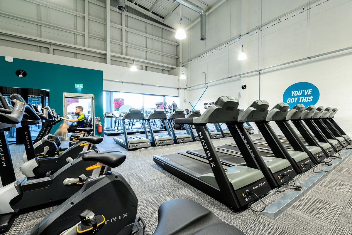 PureGym Romford: Rows of treadmills, exercise bikes, and weight machines in a brightly lit gym interior.