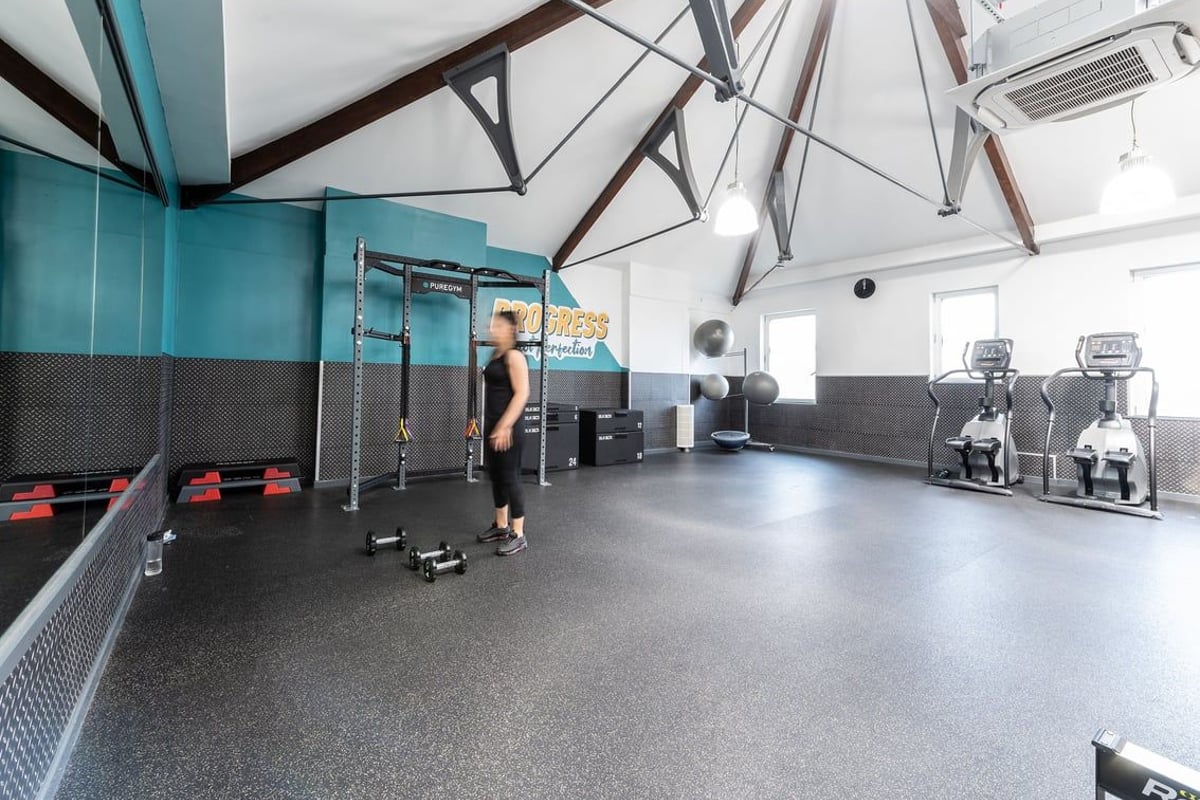PureGym London Bayswater: Functional training rig, rubberized floor, weight racks, and mirrored walls.