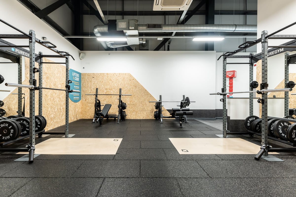 PureGym Chatham: Squat racks, weight benches, bumper plates, and rubberized flooring in a spacious weight training area.