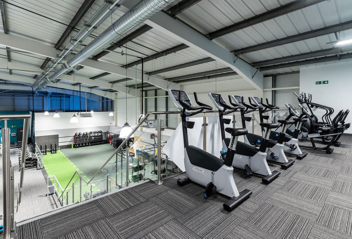 PureGym Torquay Bridge Retail Park: Rows of stationary bikes, treadmills, and weight machines in a bright gym interior.