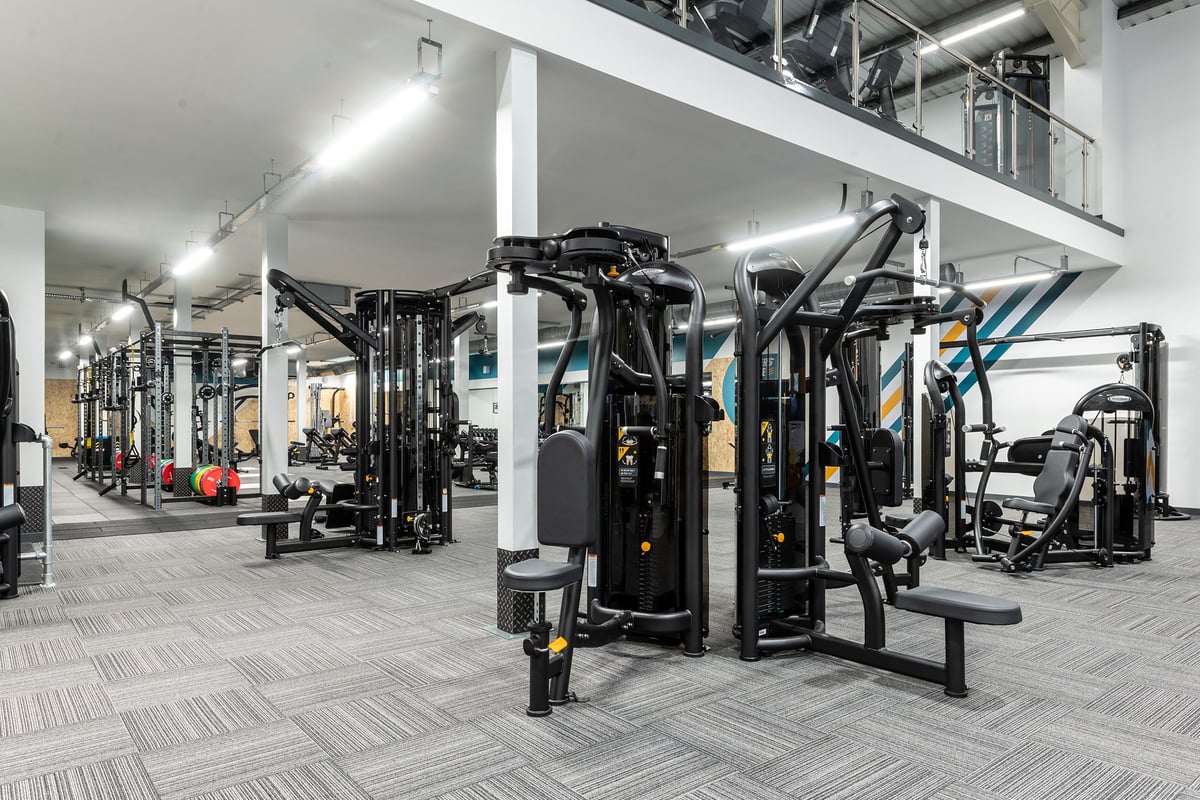 PureGym Macclesfield Silk Road: Gym weights machines, benches, mirrors, and rubberized flooring in a spacious fitness area.