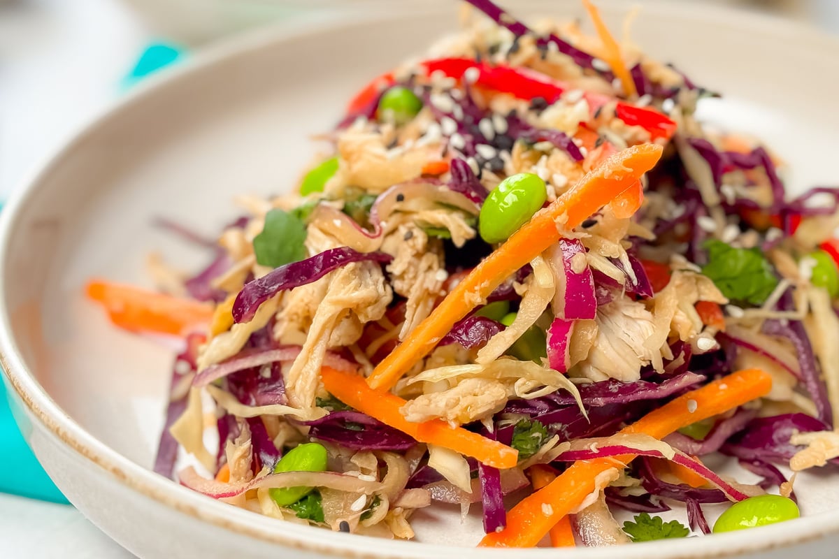 Colourful salad with shredded chicken, purple cabbage, carrots, edamame and sesame seeds