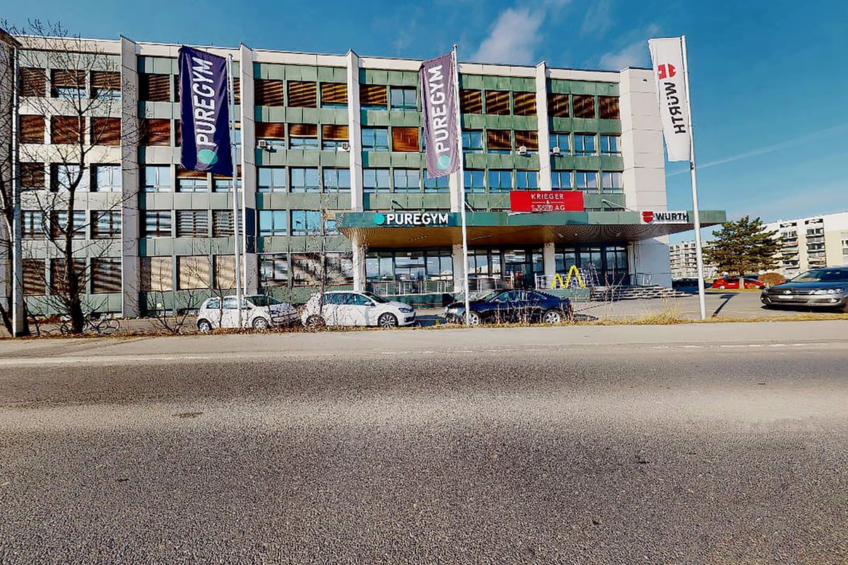 PureGym Kriens: Multistory commercial building facade with signage for fitness brands and businesses.