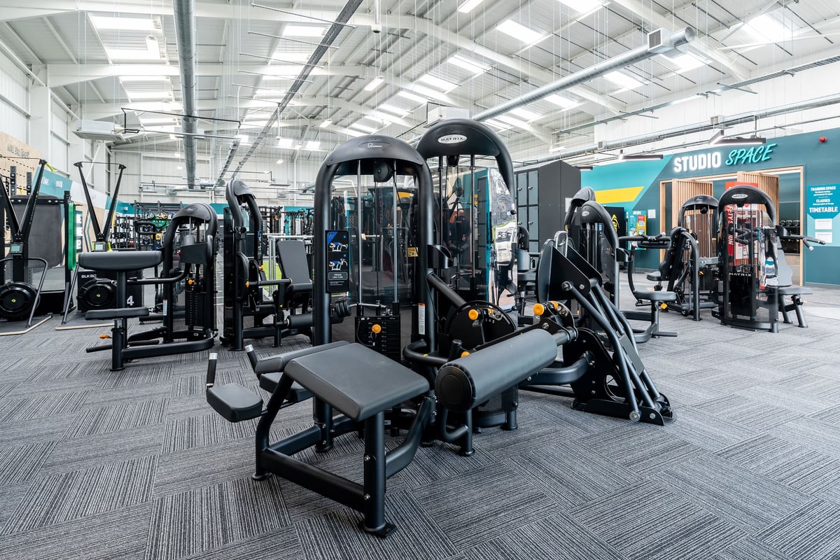 PureGym Keighley: Resistance machines, benches, free weights, mirrors in a brightly-lit fitness studio.