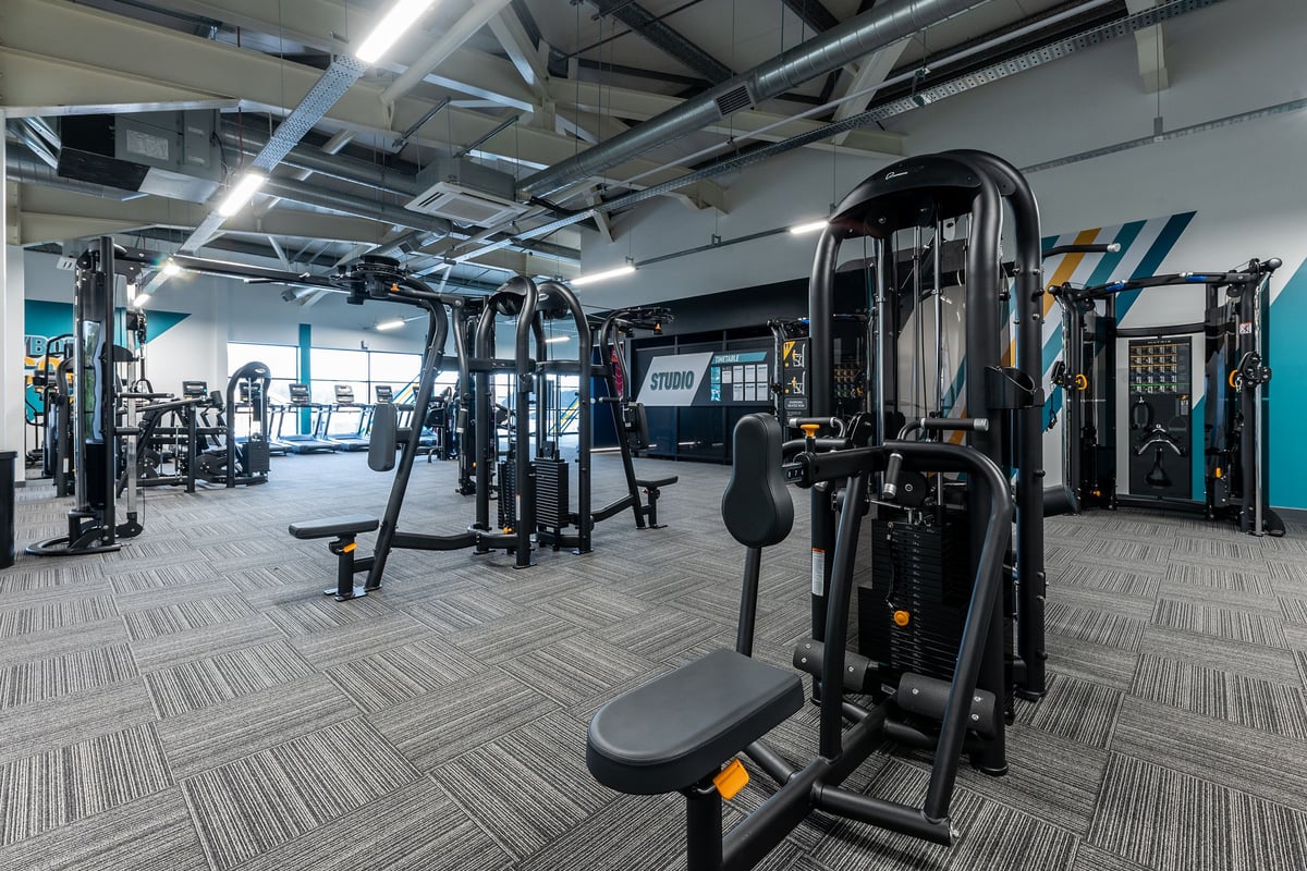 PureGym Glasgow Milngavie: Weight machines, resistance equipment, rubberized flooring, and workout space with ample lighting.