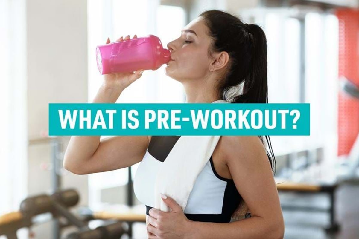 Woman in gym drinking from pink bottle with towel around neck and text overlay