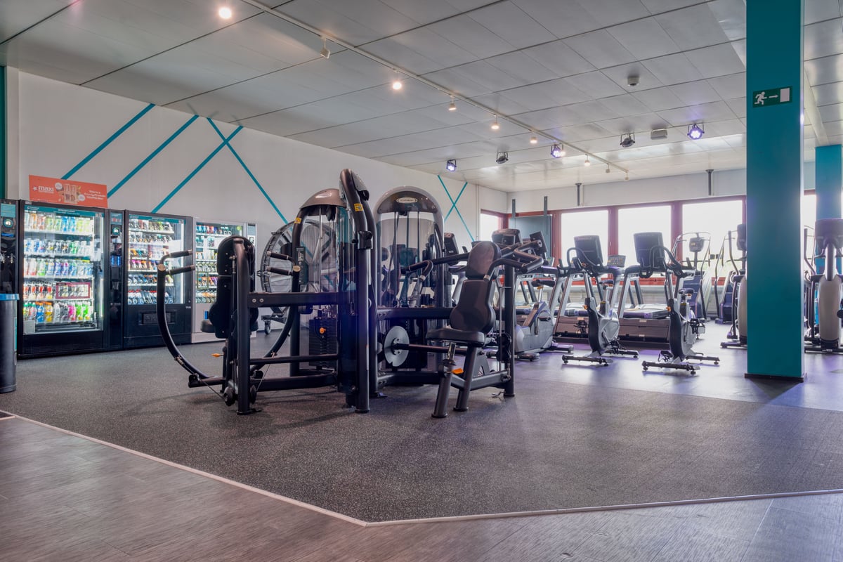 alle du gym avec machines de musculation et vélos cardio