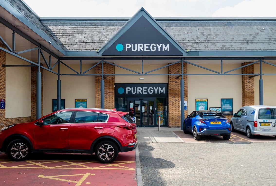 PureGym Linlithgow: Gym exterior with branded signage, parking spaces, and cars outside.