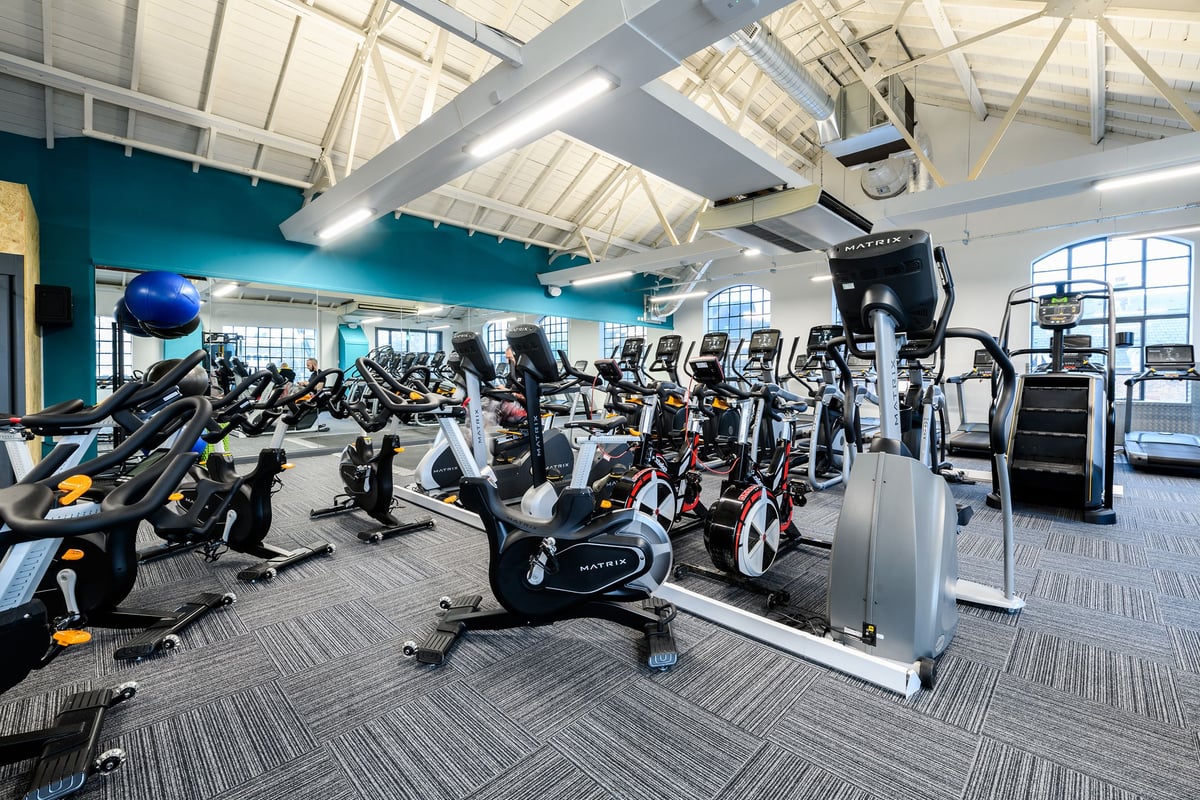 PureGym London Bow Wharf: Rows of stationary bikes, treadmills, elliptical trainers in a bright gym interior.