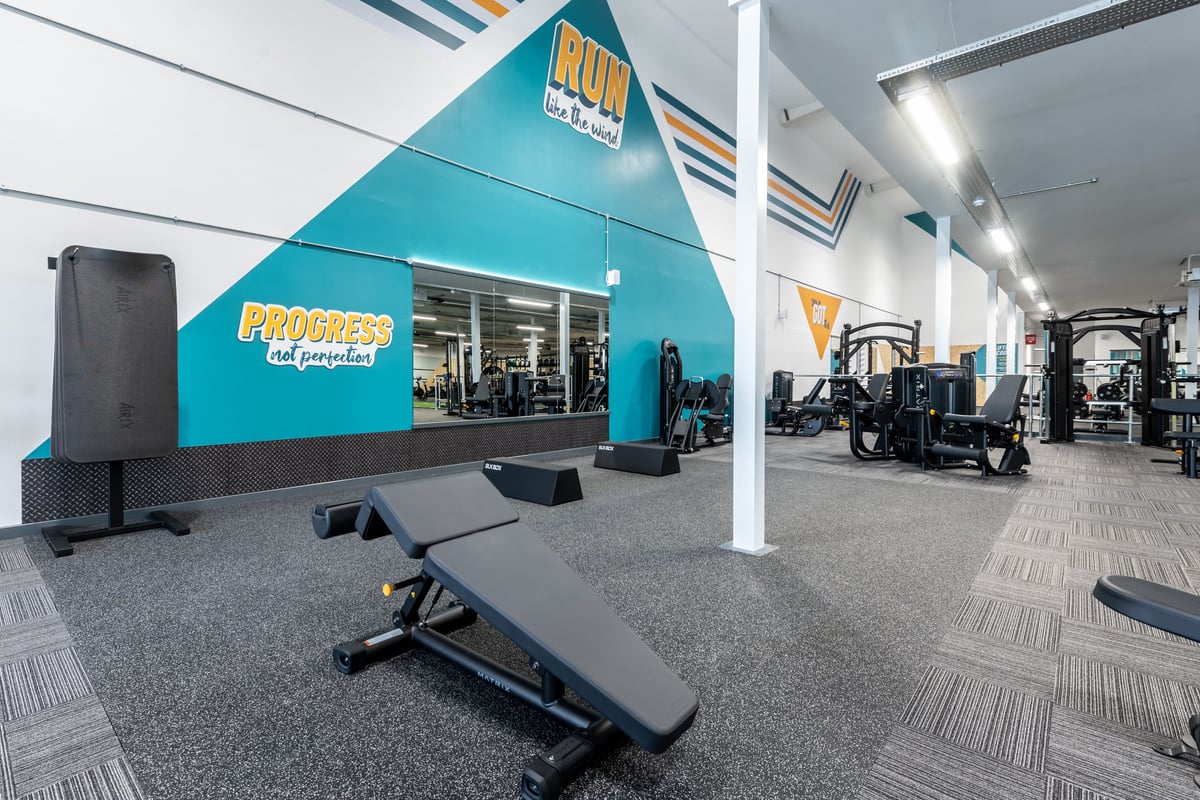 PureGym Peterborough Brotherhood Retail Park: Gym studio with padded benches, resistance machines, and mirrored walls.