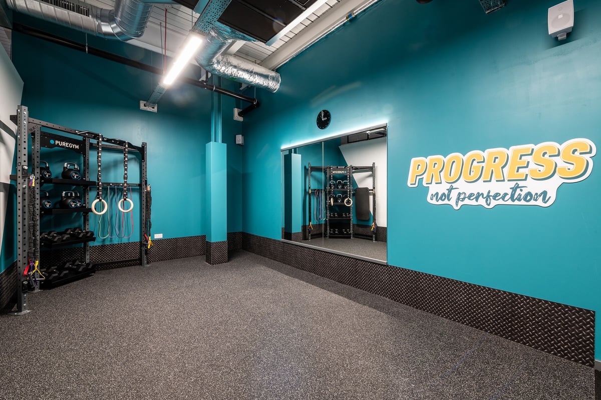 PureGym London Colney: Functional training area with squat racks, weight plates, and rubberized flooring.