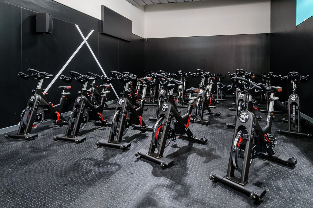 PureGym Leicester Walnut Street: Rows of stationary bikes inside a dimly lit fitness studio.