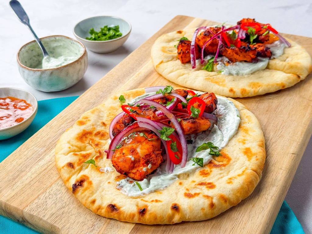 Flatbreads topped with grilled chicken, yoghurt sauce, red onion, chilli, and herbs
