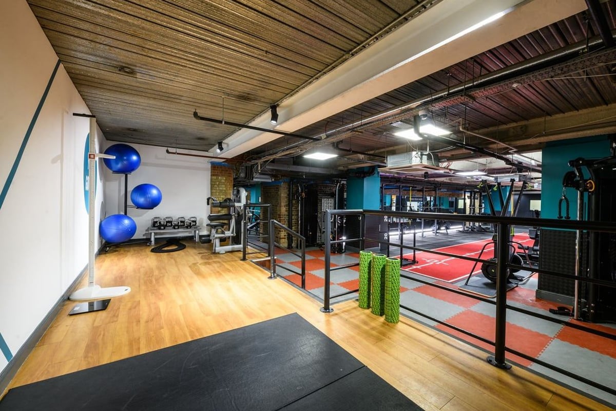 PureGym London Tower Hill: Rubberized flooring, weight racks, punching bags, exercise balls, and mirrored studio walls.