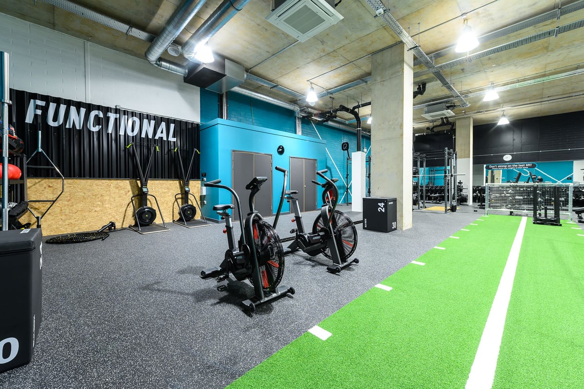 PureGym London Kidbrooke Village: Spin bikes, rowers, weightlifting area with turf, functional training rig.