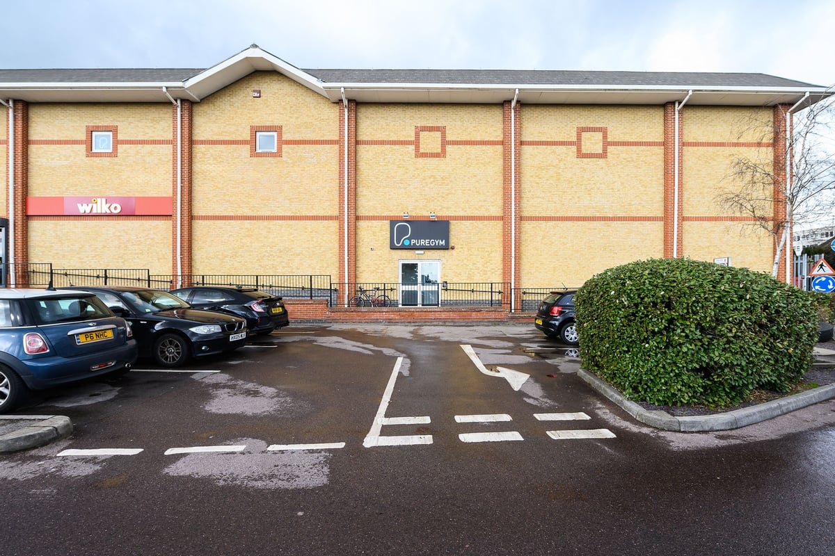 PureGym Waterlooville: Exterior of a fitness center building with branded signage and parking spaces.
