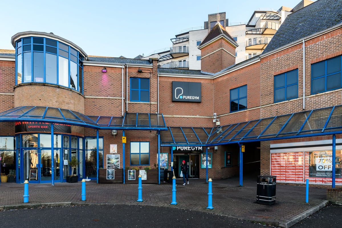 PureGym Northampton Central: Commercial gym exterior with blue canopy over entrance and outdoor seating area.