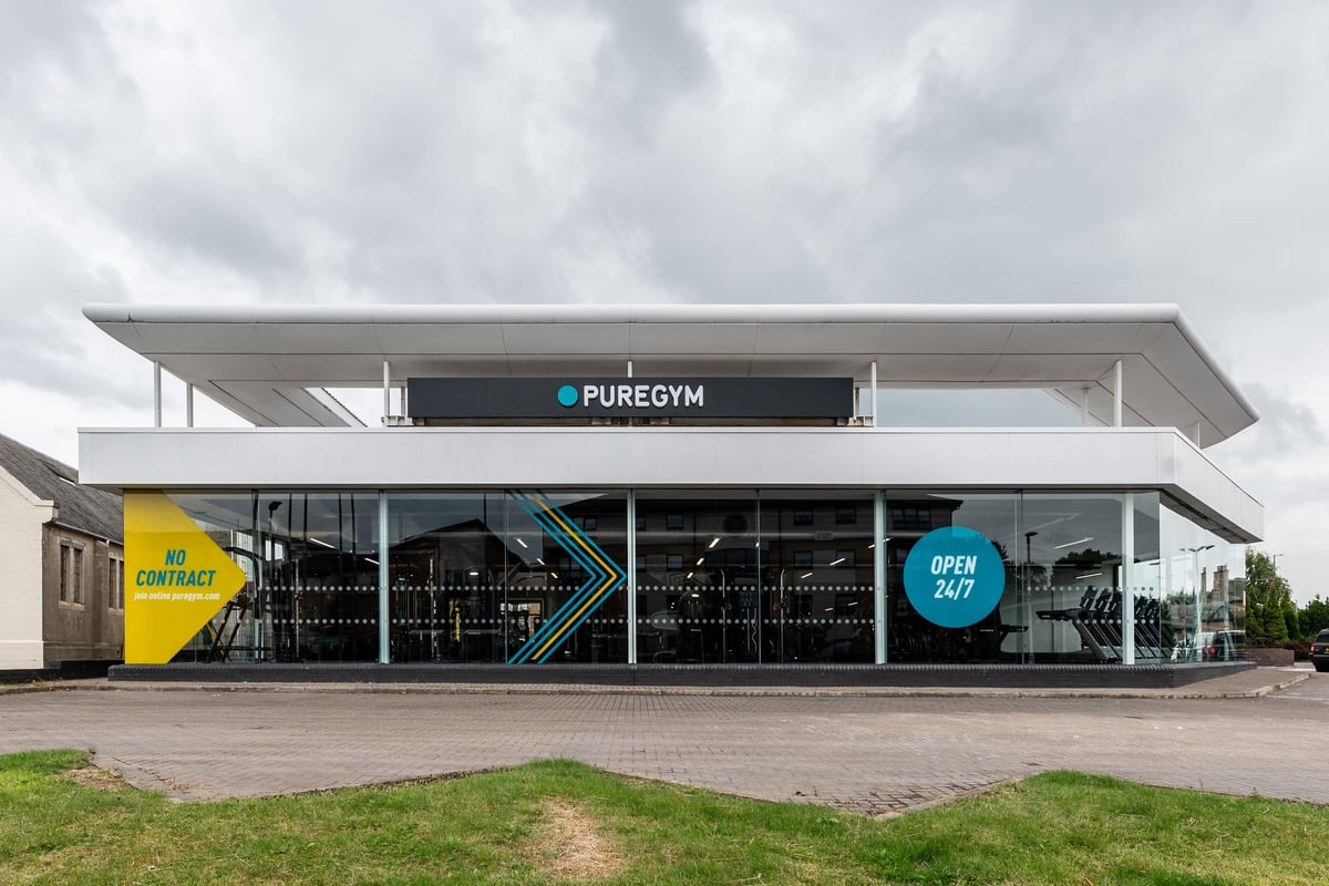 PureGym Glasgow Giffnock: Modern gym exterior with signage, glass facade, and parking area visible.