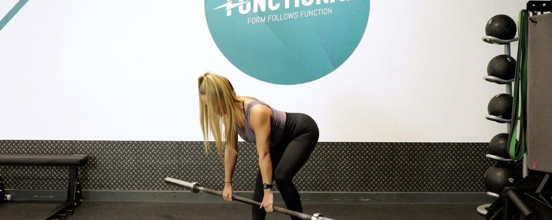 Woman leaning forward with a barbell