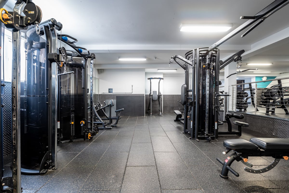 PureGym Sutton Coldfield: Resistance machines, cable crossover stations, free weights and benches in a bright gym interior.