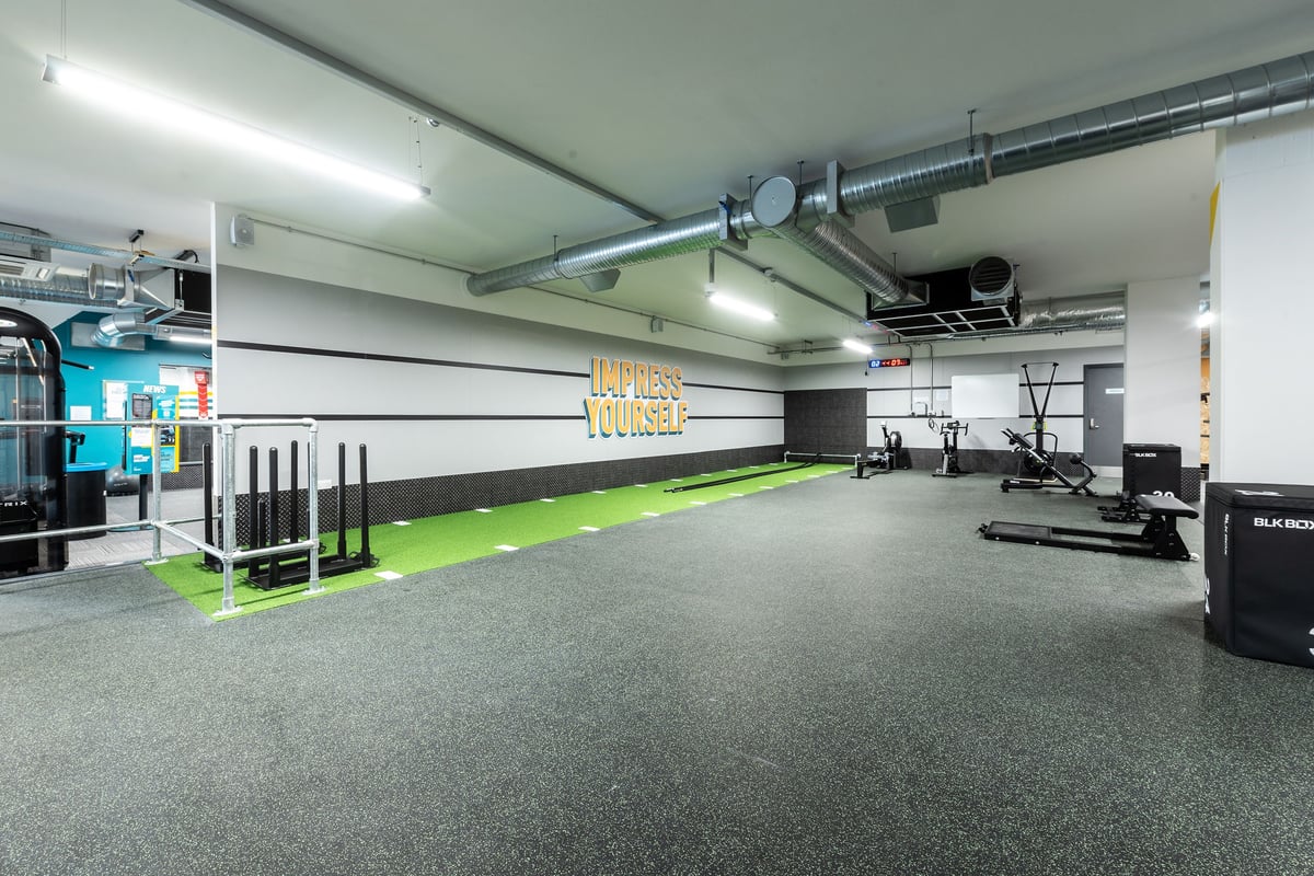 PureGym London Swanley: Large open gym space with weight racks, turf area, rubberized flooring, and equipment along walls.