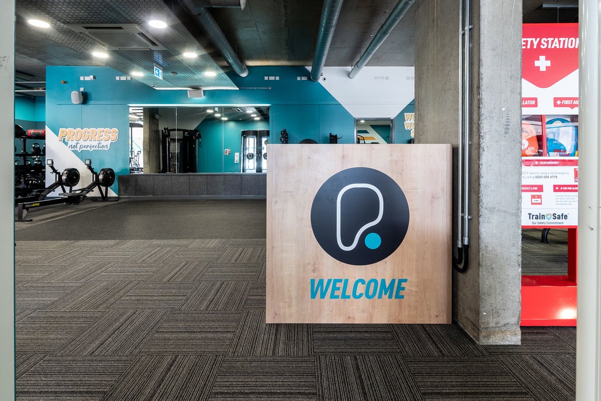 PureGym London Limehouse: Reception area with workout equipment visible, rubberized flooring.