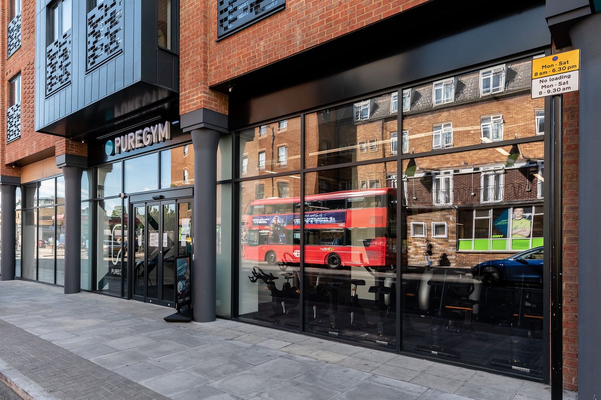 PureGym London Crouch End: Pure Gym storefront with red double-decker bus reflected in window.