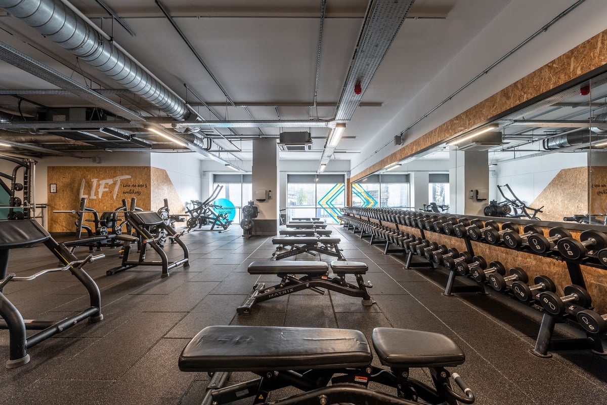 PureGym Stevenage: Rows of treadmills, exercise bikes, weight benches, and free weights in a industrial-style gym.